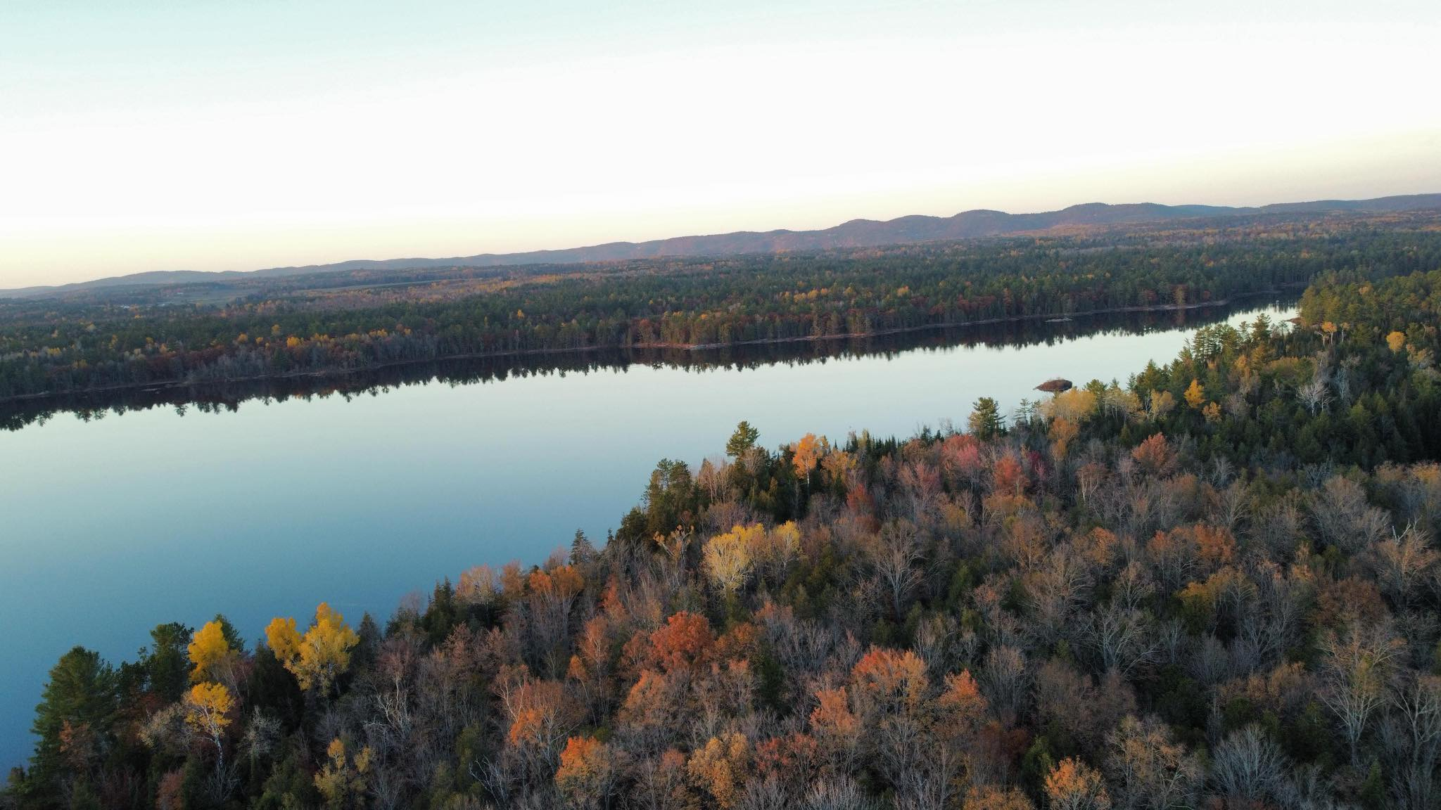 Wide aerial view across the forested waterfront